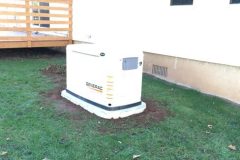 Generac home generator installed on grass near a house.