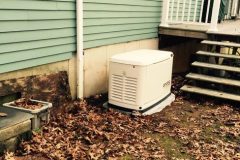 A PE Home Generators unit installed beside a house.