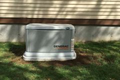 Generac home generator installed on grass near a house.