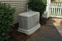 Home standby generator for backup power installed beside a house.